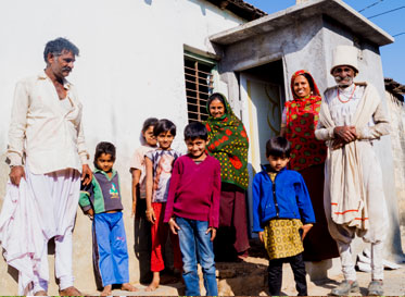 A family poses beside their newly constructed toilet