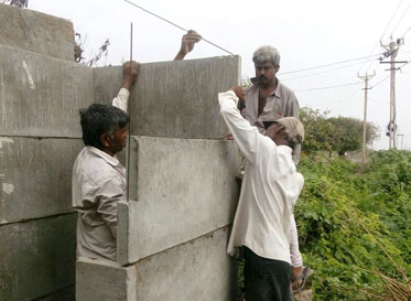 A prefabricated superstructure for a toilet being erected in a village
