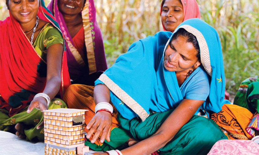 Matu Bai, a member of the water-user group of Bhula village in Sirohi, uses a fabricated model to explain the design of a twin-pit toilet. Mobilising households to construct and use toilets was an important part of the behaviour change campaign.