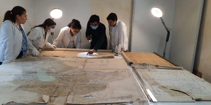 The HIMSHACO conservation team working on the historical maps received by the Kumaon Commissioner's office.