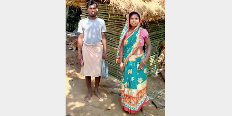 Rekha Devi with her husband outside their goat shed in their house backyard