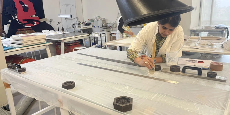 Conservator Keerat Garcha working on Arunima Choudhury's eco-prints, getting them ready for display.